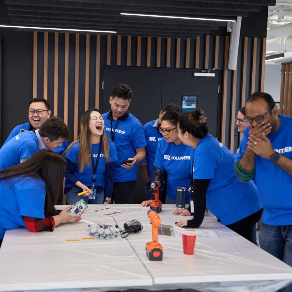 Team laughing during MudPie build (blue volunteer shirts)